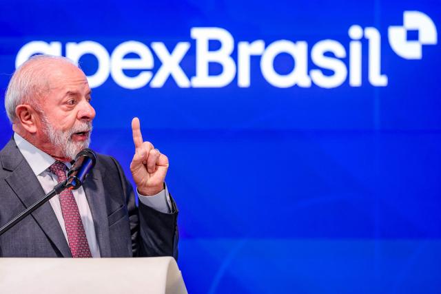 Brazilian President Luiz Inacio Lula da Silva speaks at the booth of Brazilian Trade and Investment Promotion Agency "apexBrasil" during a tour of the Hannover industrial trade fair for mechanical and electrical engineering and digital industries, in Hannover, northern Germany on April 20, 2026. The fair opens its doors to the public on April 20 and will be running until April 24, 2026. (Photo by Ronny HARTMANN / AFP)