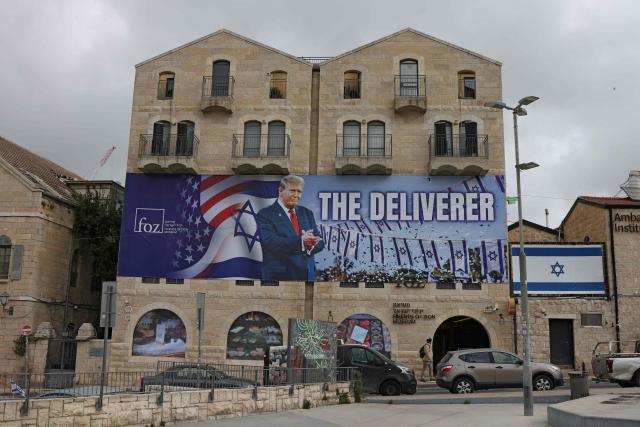 A photograph shows a banner depicting US President Donald Trump with the slogan “The Deliverer” in Jerusalem on April 20, 2026. Iran is not currently planning to attend talks with the United States, state media said, after the US president ordered US negotiators to travel to Pakistan on April 20, just days before a ceasefire in the Middle East expires. (Photo by AHMAD GHARABLI / AFP) / 