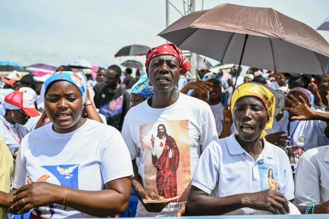Faithfuls sing as they gather ahead of Pope Leo XIV's Holy Mass at the Saurimo esplanade in Saurimo on the eighth day of an 11-day apostolic journey to Africa, on April 20, 2026. (Photo by Alberto PIZZOLI / AFP)