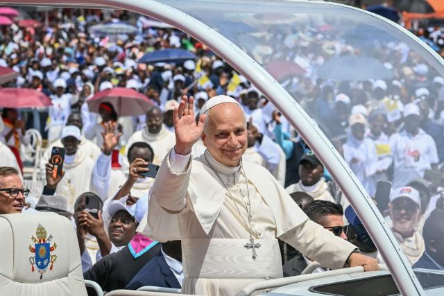 Pope Leo XIV (C) waves to the crowd from the Popemobile as he arrives to lead the Holy Mass at the Saurimo esplanade in Saurimo on the eighth day of an 11-day apostolic journey to Africa, on April 20, 2026. (Photo by Alberto PIZZOLI / AFP)