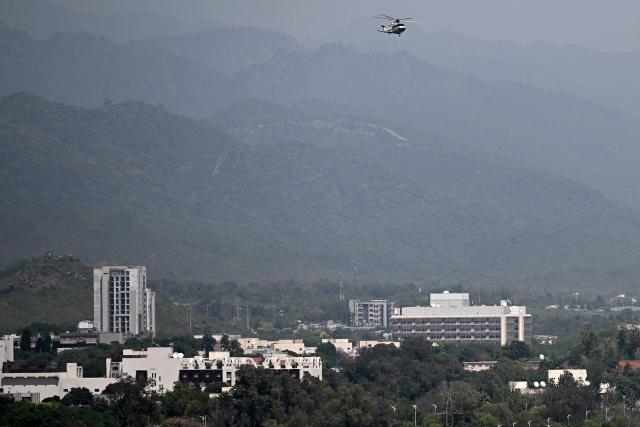 A helicopter flies over Serena Hotel (front L) amid heightened security measures at the Red Zone area in Islamabad on April 20, 2026, ahead of anticipated US-Iran peace talks. Iran insisted it has no plan to attend a new round of negotiations with the United States on April 20, as uncertainty grows over a push to stop the Middle East war from resuming. (Photo by Aamir QURESHI / AFP)