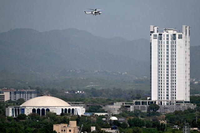 A helicopter flies over the Red Zone area in Islamabad on April 20, 2026, amid heightened security measures ahead of anticipated US-Iran peace talks. Iran insisted it has no plan to attend a new round of negotiations with the United States on April 20, as uncertainty grows over a push to stop the Middle East war from resuming. (Photo by Aamir QURESHI / AFP)