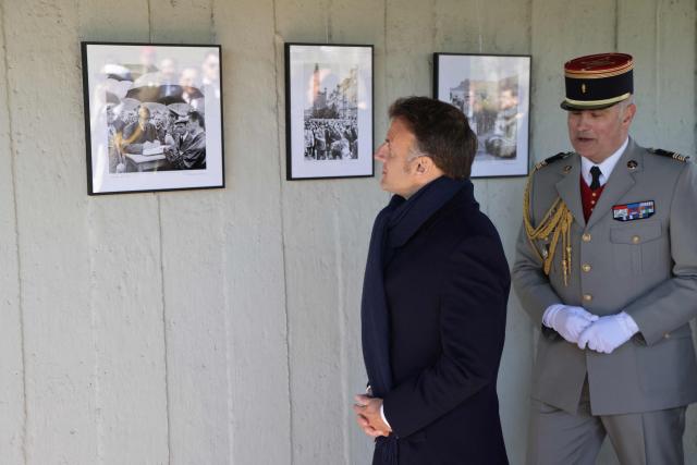 French President Emmanuel Macron (L) looks at the pictures of French President Charles de Gaulle's official visit in 1967 in the French military cemetery on April 20, 2026 in Gdansk, Poland, at the start of his one-day-visit to Poland. (Photo by Ludovic MARIN / AFP)