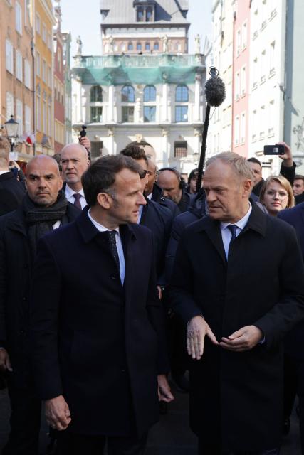 French President Emmanuel Macron (L) is welcomed by Poland's Prime Minister Donald Tusk (R) at the Golden Gate (Zlota Brama) in the city centre of Gdansk, Poland, on April 20, 2026, at the start of his one-day-visit to Poland. (Photo by Ludovic MARIN / AFP)