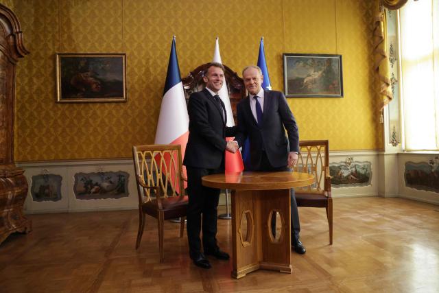 French President Emmanuel Macron (L) and Poland's Prime Minister Donald Tusk shake hands prior to their meeting in the Golden Hall of the Uphagen House (Dom Uphagena) in Gdansk, Poland, on April 20, 2026, at the start of his one-day-visit to Poland. (Photo by Ludovic MARIN / AFP)