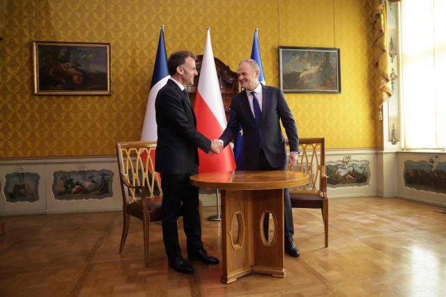 French President Emmanuel Macron (L) and Poland's Prime Minister Donald Tusk shake hands during their meeting in the Golden Hall of the Uphagen House (Dom Uphagena) in Gdansk, Poland, on April 20, 2026, at the start of his one-day-visit to Poland. (Photo by Ludovic MARIN / AFP)