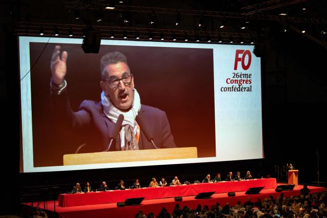 This photograph shows a general view with General secretary of the French labor union Force Ouvrière (FO) Frederic Souillot showed on screen delivering a speech at the 26th national convention of the French labor union Force Ouvrière (FO) in Dijon, central-eastern France, on April 20, 2026. The secretary general of French labour union Force Ouvrière (FO), opened on April 20, 2026, the 26th congress of Frances third-largest trade union, which is being held in Dijon until Friday, by welcoming, to loud applause two of its recently released activists and former detainees in Iran. (Photo by ARNAUD FINISTRE / AFP)