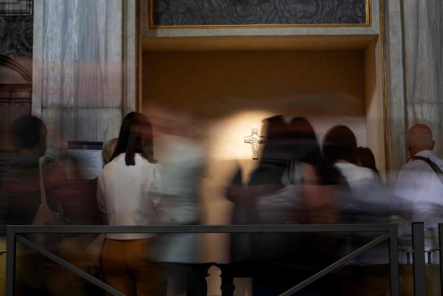 A slow-shutter image shows people standing before Pope Francis’s tomb at the Basilica of Saint Mary Major, a year after his death, in Rome on April 20, 2026. (Photo by Tiziana FABI / AFP)