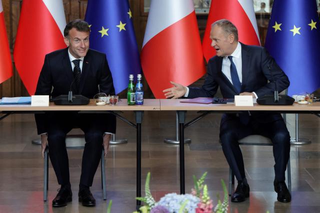 French President Emmanuel Macron and Poland's Prime Minister Donald Tusk (R) attend a meeting in the Great Hall at the Artus Court (Dwor Artusa) in Gdansk, Poland, on April 20, 2026 during the French President's one-day visit to Poland. (Photo by Ludovic MARIN / AFP)