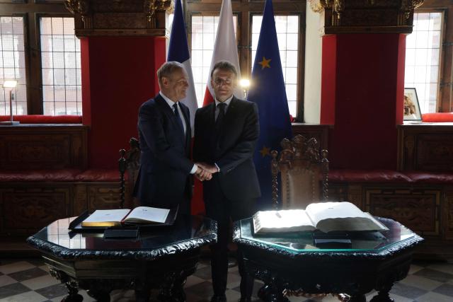 CORRECTION / French President Emmanuel Macron and Poland's Prime Minister Donald Tusk shake hands at the signing of the golden book at the Main Town Hall in Gdansk, Poland, on April 20, 2026 during the French President's one-day-visit to Poland. (Photo by Ludovic MARIN / AFP) / “The erroneous mention[s] appearing in the metadata of this photo by Ludovic MARIN has been modified in AFP systems in the following manner: [Main Town Hall] instead of [the Artus Court (Dwor Artusa)]. Please immediately remove the erroneous mention[s] from all your online services and delete it (them) from your servers. If you have been authorized by AFP to distribute it (them) to third parties, please ensure that the same actions are carried out by them. Failure to promptly comply with these instructions will entail liability on your part for any continued or post notification usage. Therefore we thank you very much for all your attention and prompt action. We are sorry for the inconvenience this notification may cause and remain at your disposal for any further information you may require.”