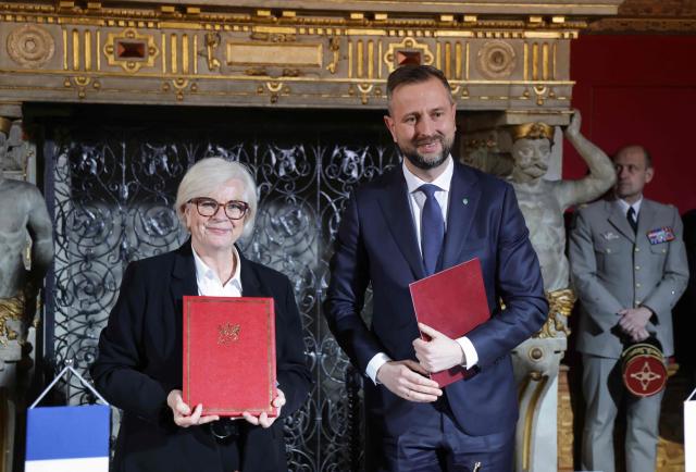 France's Defence Minister Catherine Vautrin (L) and Polish Defence Minister Wladyslaw Kosiniak-Kamysz (R) pose with documents after signing an agreement at the Main Town Hall in Gdansk, Poland, on April 20, 2026 during the French President's one-day visit to Poland. (Photo by Ludovic MARIN / AFP)