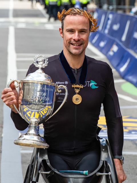 Marcel Hug from Switzerland holds the trophy after winning the men's wheelchair division during the 130th Boston Marathon on April 20, 2026, in Boston, Massachusetts. (Photo by Joseph Prezioso / AFP)
