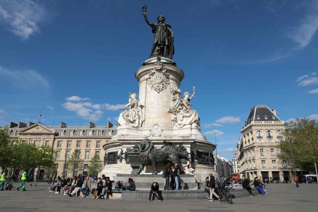 Local residents sit at the foot of the Statue de la Republique at Place de la Republique in Paris on April 20, 2026. (Photo by Charlotte SIEMON / AFP)