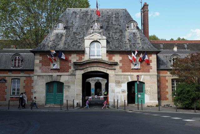 Pedestrians walk past an entrance of the Hopital Saint-Louis hospital in Paris on April 20, 2026. (Photo by Charlotte SIEMON / AFP)