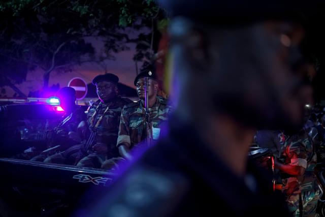 Angolan soldiers sit on the back of a pick-up truck as they patrol while Pope Leo XIV leaves after meeting with bishops at the Parish of our Lady of Fatima in Luanda on the eighth day of an 11-day apostolic journey to Africa, on April 20, 2026. (Photo by PHILL MAGAKOE / AFP)