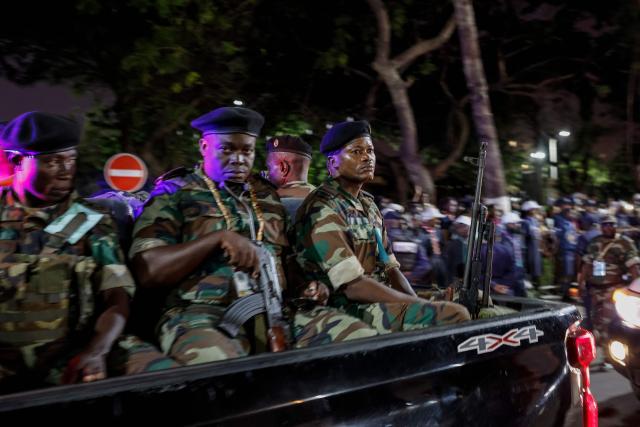 TOPSHOT - Angolan soldiers sit on the back of a pick-up truck as they patrol while Pope Leo XIV leaves after meeting with bishops at the Parish of our Lady of Fatima in Luanda on the eighth day of an 11-day apostolic journey to Africa, on April 20, 2026. (Photo by PHILL MAGAKOE / AFP)