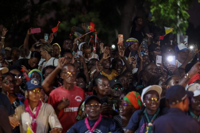 A crowd gathering outside reacts before Pope Leo XIV leaves after meeting with bishops at the Parish of our Lady of Fatima in Luanda on the eighth day of an 11-day apostolic journey to Africa, on April 20, 2026. (Photo by PHILL MAGAKOE / AFP)