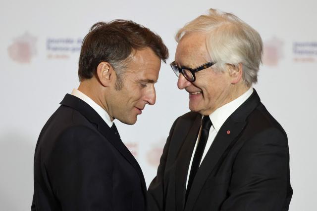 French President Emmanuel Macron (L) congratulates Bronislaw Geremek Award laureate and Polish actor and director Andrzej Seweryn during the ceremony for the presentation of the Bronislaw Geremek Award at the European Solidarity Centre in Gdansk, Poland, on April 20, 2026 during the French President's one-day visit to Poland. (Photo by Ludovic MARIN / AFP)