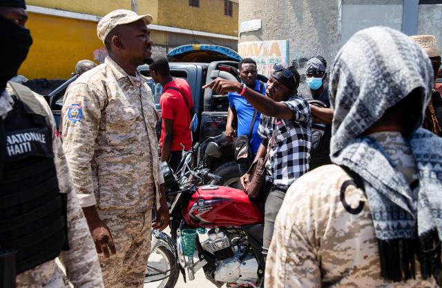 Police officers monitor the scene as protestors rally against rising fuel prices in Port-au-Prince, Haiti, on April 20, 2026. Workers say that fuel prices should not exceed their minimum wage. Oil prices surged Monday on a re-escalation of hostilities in the Middle East war after Iran closed the Strait of Hormuz at the weekend, just a day after reopening it, citing the United States' blockade of its ports. (Photo by Clarens SIFFROY / AFP)