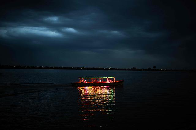 A tourist boat carries people as it navigates the Shatt al-Arab river in Basra on a cloudy evening on April 20, 2026. (Photo by Hussein FALEH / AFP)