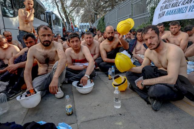 Around 90 miners stage topless a sit-in protest outside Turkey's Energy Ministry to demand unpaid wages in Ankara, on April 20, 2026. Hundreds of workers from Doruk Mining, members of the Independent Miners' Union, walked a 180-kilometre way in nine days to reach Ankara, calling on authorities to address what they described as months of delayed payments and unresolved compensation claims. (Photo by Adem ALTAN / AFP)