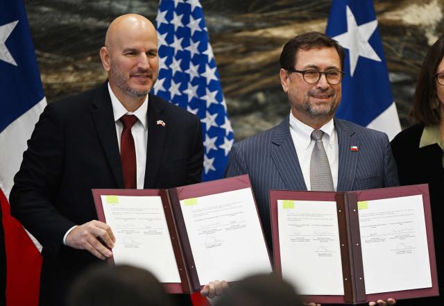 US Ambassador to Chile Brandon Judd (L) and Chilean Foreign Minister Francisco Perez Mackenna pose with agreements signed by Chile and the United States on mining and security in Santiago on April 20, 2026. (Photo by RODRIGO ARANGUA / AFP)