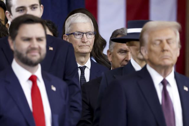 (FILES) Apple CEO Tim Cook (C) looks on behind US President Donald Trump (R) and US Vice President JD Vance (L) after the two were sworn into office at an inauguration ceremony in the rotunda of the US Capitol in Washington, DC, on January 20, 2025. Apple announced on April 20, 2026 that Cook would step down in September, handing the chief executive job to company veteran John Ternus. (Photo by SHAWN THEW / POOL / AFP)