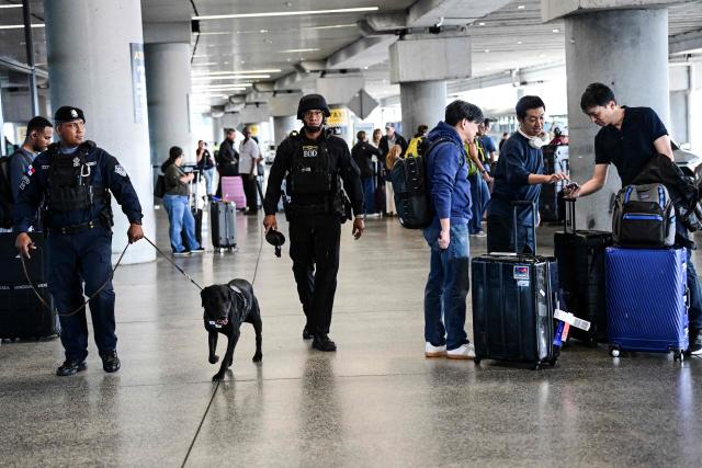 Police officers with a dog patrol Tocumen International Airport ahead of the extradition from Venezuela of Colombian-Venezuelan Ali Zaki Hage Jalil, an alleged associate of Hezbollah and a suspect in the bombing of a Panamanian commercial aircraft in July 1994 that killed 21 people, most of them Jewish, in Panama City, on April 20, 2026. (Photo by Martin BERNETTI / AFP)