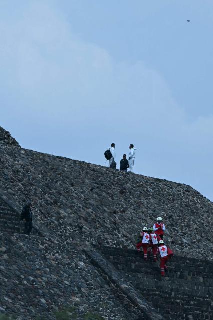 Forensic experts and members of the Red Cross work on the Pyramid of the Moon at the Teotihuacan archaeological zone following a shooting in Teotihuacan, State of Mexico, on April 20, 2026. A Canadian woman was shot dead on April 20 at the Teotihuacan pyramids archaeological zone in central Mexico by a man who later killed himself, authorities said. (Photo by YURI CORTEZ / AFP)