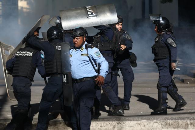 Riot police protect themselves with shields during a protest against budget cuts to university education near the National Congress in Tegucigalpa on April 20, 2026. (Photo by Johny MAGALLANES / AFP)