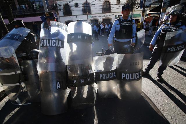 Riot police protect themselves with shields during a protest against budget cuts to university education near the National Congress in Tegucigalpa on April 20, 2026. (Photo by Johny MAGALLANES / AFP)