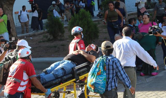 EDITORS NOTE: Graphic content / Red Cross personnel carry an injured demonstrator during a protest against budget cuts to university education near the National Congress in Tegucigalpa on April 20, 2026. (Photo by Johny MAGALLANES / AFP)