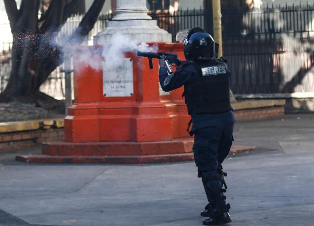 A riot police officer fires tear gas during a protest against budget cuts to university education near the National Congress in Tegucigalpa on April 20, 2026. (Photo by Johny MAGALLANES / AFP)
