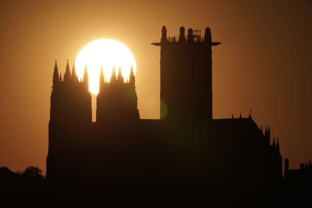 The sun sets behind the National Cathedral in Washington, DC, on April 20, 2026. (Photo by Oliver Contreras / AFP)