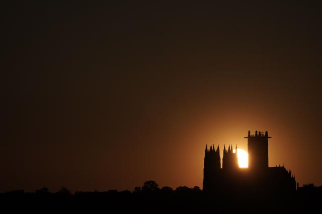 The sun sets behind the National Cathedral in Washington, DC, on April 20, 2026. (Photo by Oliver Contreras / AFP)