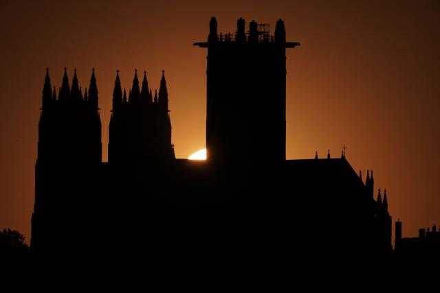 The sun sets behind the National Cathedral in Washington, DC, on April 20, 2026. (Photo by Oliver Contreras / AFP)
