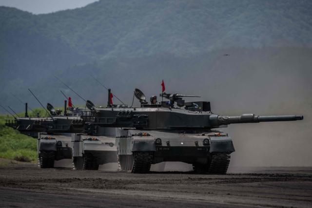 (FILES) Japan Ground Self-Defence Force (JGSDF) battle tanks take part in a live fire exercise at East Fuji Maneuver Area in Gotemba on May 27, 2023. Japan's top government spokesman Minoru Kihara said on April 21, 2026, that Tokyo would ease decades-old arms export rules, paving the way for the sale of lethal weapons overseas. (Photo by Yuichi YAMAZAKI / AFP)