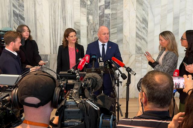 New Zealand Prime Minister Christopher Luxon speaks at a press conference besides National Party deputy leader Nicola Willis in Wellington on April 21, 2026. Luxon survived a leadership vote after a run of poor polls stoked speculation about his future. (Photo by Ben STRANG / AFP)
