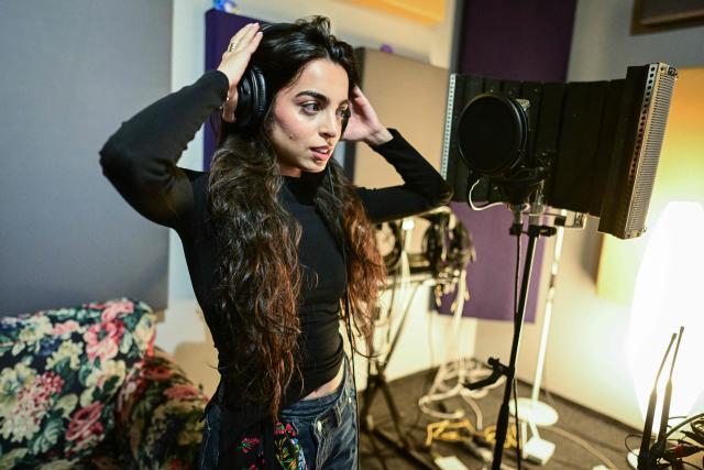 Singer Bianca Mihai, 25, is pictured during a rehersal at a studio in Bucharest on March 26, 2026. While the sultry songs of Lolita Cercel, an artist created with AI that has drawn racism concerns in Romania, have gathered millions of views online, singer Bianca Mihai works hard without the same recognition. Lolita's popularity has stirred questions in Romania about artificial intelligence replacing humans, as well as stereotypes in a country with a history of discriminating against the Roma. Lolita creator Tom, who has described his project as "a fusion of Balkan nostalgia and the synthetic future", insists Lolita "doesn't necessarily belong to a specific culture". (Photo by Daniel MIHAILESCU / AFP)