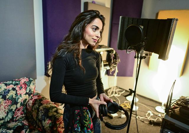 Singer Bianca Mihai, 25, is pictured during a rehersal at a studio in Bucharest on March 26, 2026. While the sultry songs of Lolita Cercel, an artist created with AI that has drawn racism concerns in Romania, have gathered millions of views online, singer Bianca Mihai works hard without the same recognition. Lolita's popularity has stirred questions in Romania about artificial intelligence replacing humans, as well as stereotypes in a country with a history of discriminating against the Roma. Lolita creator Tom, who has described his project as "a fusion of Balkan nostalgia and the synthetic future", insists Lolita "doesn't necessarily belong to a specific culture". (Photo by Daniel MIHAILESCU / AFP)