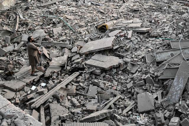 (FILES) A local stands over the debris of destroyed structures after Indian strikes inside the Government Health and Educational complex in Muridke about 30 kilometres from Lahore on May 7, 2025. Relations between nuclear-armed neighbours India and Pakistan plummeted last year in 2025 after an April 22 attack in Indian-administered Kashmir killed 26 men, mostly Hindu tourists, leading to their worst conflict in decades -- triggering tit-for-tat diplomatic measures and a sharp military escalation that killed more than 70 people on both sides. (Photo by Farooq NAEEM / AFP)