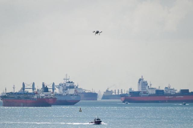 This picture shows vessels anchored as a drone flies along the Singapore straits eastern anchorage in Singapore on April 21, 2026. (Photo by Roslan RAHMAN / AFP)