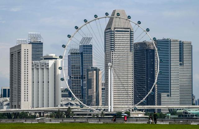 The Singapore flyer observation wheel sits against the high-rise buildings in Singapore on April 21, 2026. (Photo by Roslan RAHMAN / AFP)