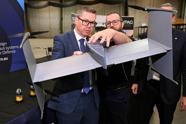 Australia's Minister for Defence Industry Pat Conroy (L) inspects a drone interceptor as the Australian Government announces it will invest 5 billion USD over the next decade in counter drones for the Australian Defence Force (ADF), in Melbourne on April 21, 2026 (Photo by William WEST / AFP)