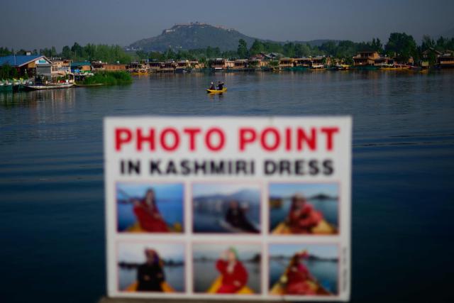 A boatman rows a small boat at the iconic Dal Lake in Srinagar on April 21, 2026. In the once-booming resort towns of India-controlled Kashmir, hoteliers are switching on the lights to welcome a trickle of visitors, a year after militants opened fire on holidaymakers in an attack that killed 26 people. (Photo by MANAN VATSYAYANA / AFP)