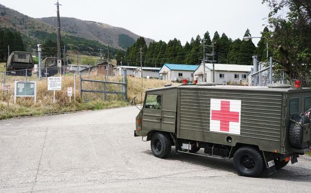 A vehicle enters the Japan Ground Self-Defence Force's (SFD) Hoshino Training Area, on April 21, 2026 in Kusu Town, Oita Prefecture, after three members of a tank crew were killed in a training excercise. An explosion in a tank during a military exercise in Japan killed three soldiers, Prime Minister Sanae Takaichi said. The unusual accident at a training ground used by Japan's Self-Defence Forces in the southwestern Oita region saw "the tank's ammunition misfire inside," killing the three crew members on board and injuring another, Takaichi said. (Photo by JIJI Press / AFP) / Japan OUT