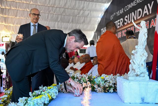 United Nations Resident Coordinator in Sri Lanka, Marc-André Franche (C) places candles as he pays homage to the victims of 2019 Easter Sunday bombings, during its 7th anniversary at the St. Anthony's Church in Colombo on April 21, 2026. Seven years after Sri Lanka's Easter Sunday bomb blasts that killed 279 people, survivors still bear deep physical and emotional scars, compounded by the failure of successive governments to deliver justice. Coordinated suicide bombings targeted three churches and three luxury hotels on April 21, 2019. (Photo by Ishara S. KODIKARA / AFP)