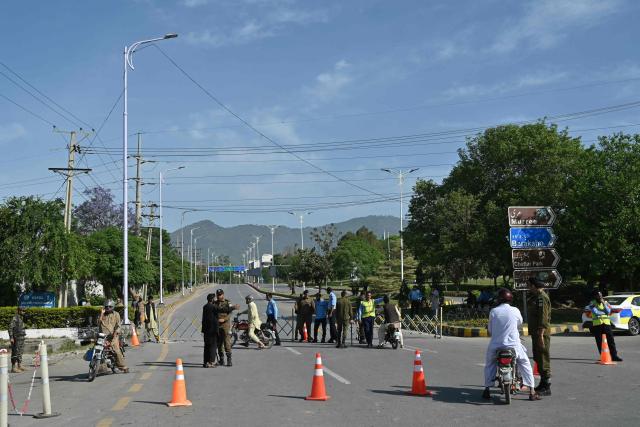 Security personnel guide commuters for alternate routes from a checkpoint near the Serena Hotel at the Red Zone area in Islamabad on April 21, 2026, amid heightened security measures ahead of US-Iran peace talks. Pakistan's Prime Minister Shehbaz Sharif said on April 19 he had spoken by phone with Iranian President Masoud Pezeshkian ahead of anticipated US-Iran talks in Islamabad, and reaffirmed his government's readiness to mediate the conflict. US President Donald Trump is sending negotiators to Pakistan on April 20 for talks with Iran just days before a ceasefire in the Middle East expires, though Tehran has reportedly yet to decide whether it will participate. (Photo by Asif HASSAN / AFP)