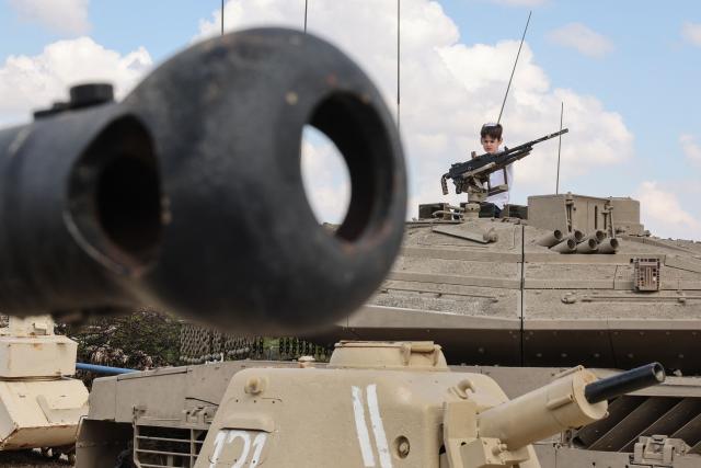 A child climbs atop old tanks and military vehicles at the Israeli Armoured Corps memorial in Latrun, between Jerusalem and Tel Aviv, on April 21, 2026, the day after Israel commemorates Remembrance Day for fallen soldiers or Yom HaZikaron. At sunset on April 20, gatherings at military cemeteries and war memorials took place to commemorate Remembrance Day which gives way to public performances, street parties and general merrymaking to mark 78 years since the declaration of the Israeli state in 1948. (Photo by Jack GUEZ / AFP)