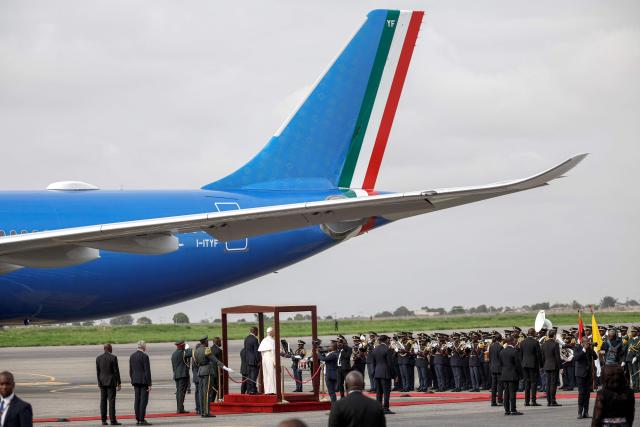 Pope Leo XIV (CR) and Angola's President Joao Lourenco (CL) watch the military band perform at the Pope's farewell ceremony at the "4 de Fevereiro" Luanda International Airport in Luanda on the ninth day of an 11-day apostolic journey to Africa, on April 21, 2026. (Photo by PHILL MAGAKOE / AFP)